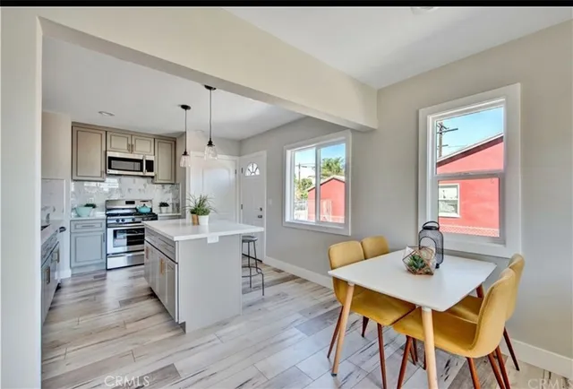 a kitchen with a table chairs refrigerator and microwave