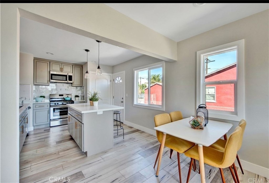 907 West Arbutus Street Compton, CA 90220 - Photo 4 of 8 a kitchen with a table chairs refrigerator and microwave