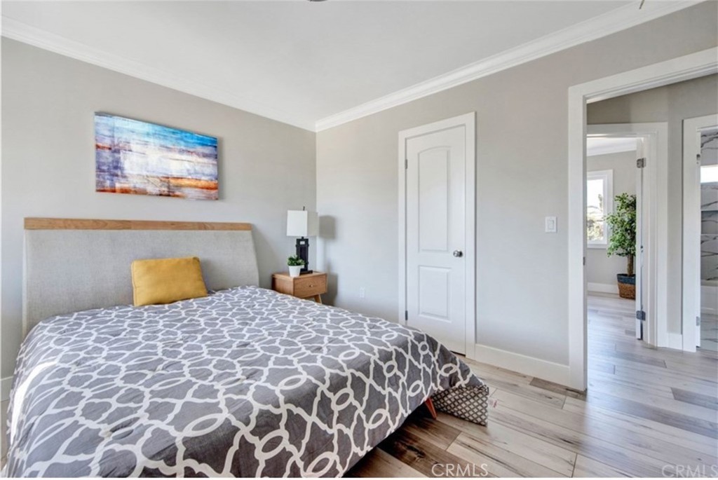 907 West Arbutus Street Compton, CA 90220 - Photo 5 of 8 a bedroom with a large bed and wooden floor