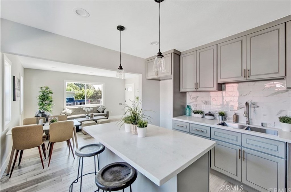 907 West Arbutus Street Compton, CA 90220 - Photo 6 of 8 a kitchen with stainless steel appliances granite countertop a stove a refrigerator a sink a dining table and chairs with wooden floor