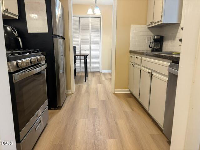 5816 Pointer Drive, Unit 102 Raleigh, NC 27609 - Photo 6 of 25 a kitchen with white cabinets and black appliances