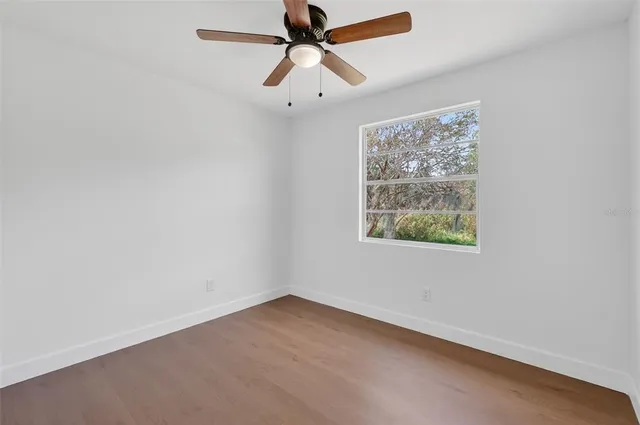an empty room with a window and a fan