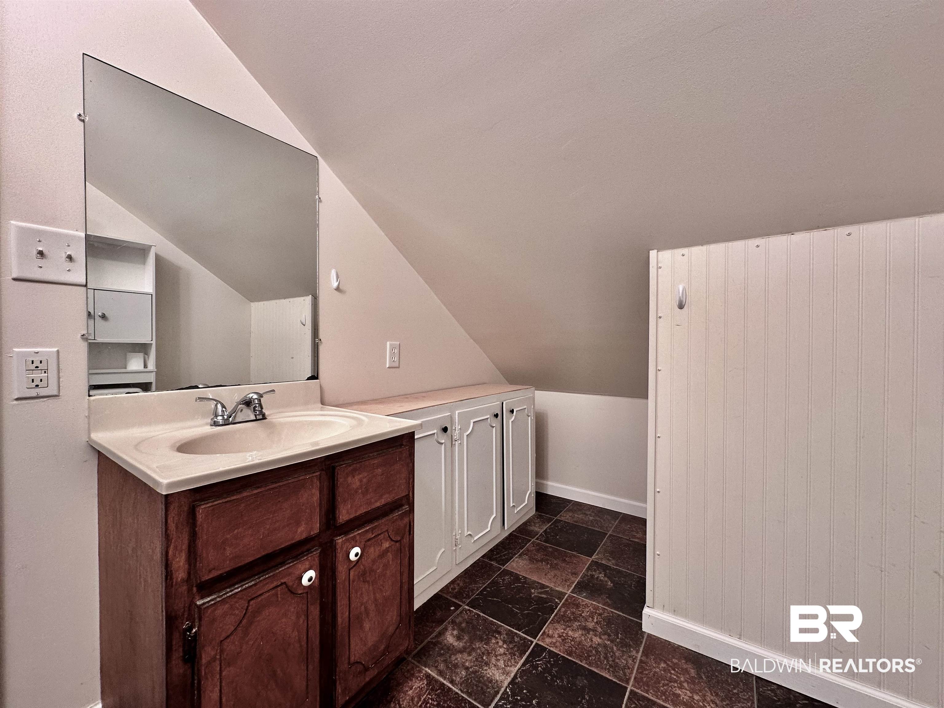 260 Siena Vista Street Mobile, AL 36607 - Photo 40 of 41 Bathroom featuring lofted ceiling, vanity, baseboards, and stone finish floors
