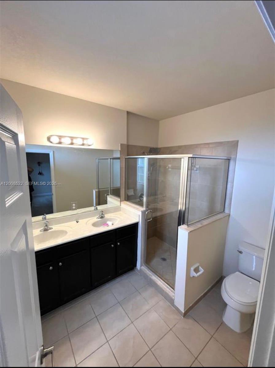 9401 Southwest 172nd Avenue, Unit 9401 Miami, FL 33196 - Photo 22 of 34 a bathroom with a sink mirror vanity and toilet