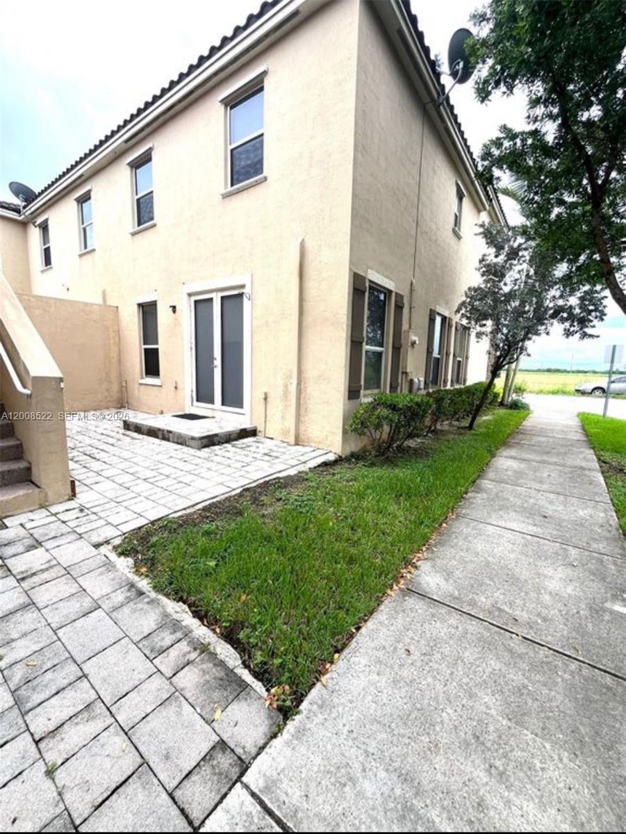 9401 Southwest 172nd Avenue, Unit 9401 Miami, FL 33196 - Photo 31 of 34 a front view of a house with a yard and trees
