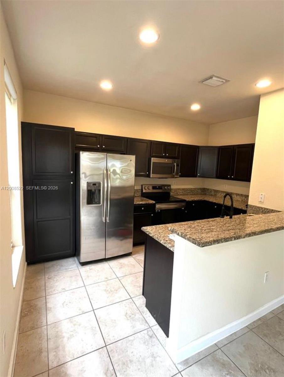 9401 Southwest 172nd Avenue, Unit 9401 Miami, FL 33196 - Photo 10 of 34 a kitchen with stainless steel appliances granite countertop a refrigerator and a sink