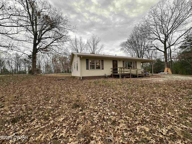 a front view of house with yard and trees around