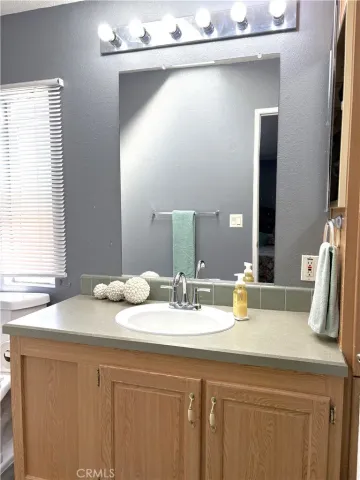 a bathroom with a granite countertop sink and a mirror