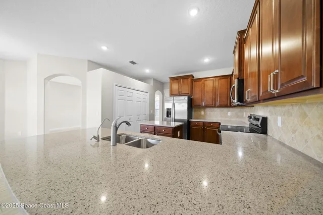 wooden floor in an empty room with a kitchen