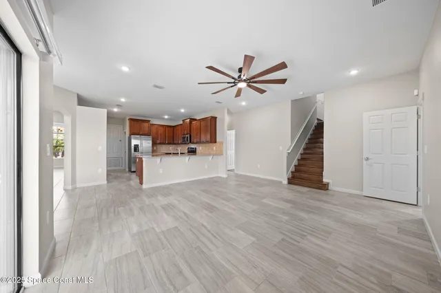 a view of kitchen with kitchen island a sink wooden floor and a refrigerator