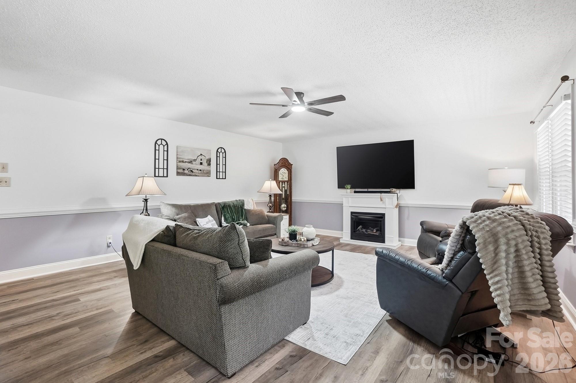 4017 Mullis Newsome Road Monroe, NC 28110 - Photo 12 of 38 a living room with furniture a fireplace and a flat screen tv