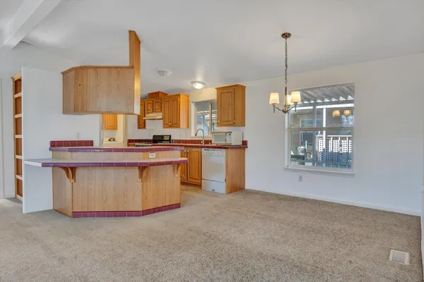 a kitchen with stainless steel appliances granite countertop a stove a sink and a wooden floors