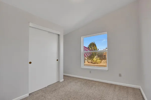an empty room with painting and view of hallway