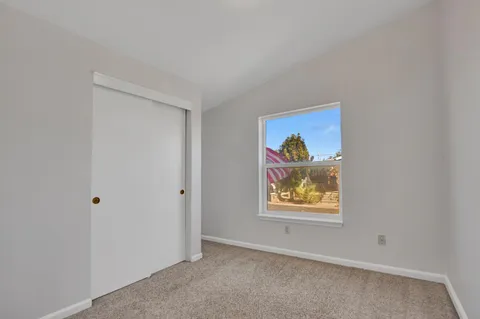 an empty room with painting and view of hallway