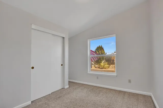 an empty room with painting and view of hallway