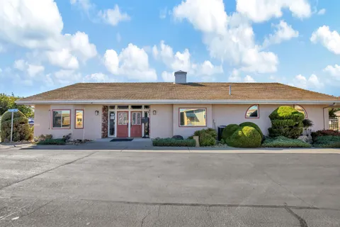 a front view of a house with a yard and outdoor seating