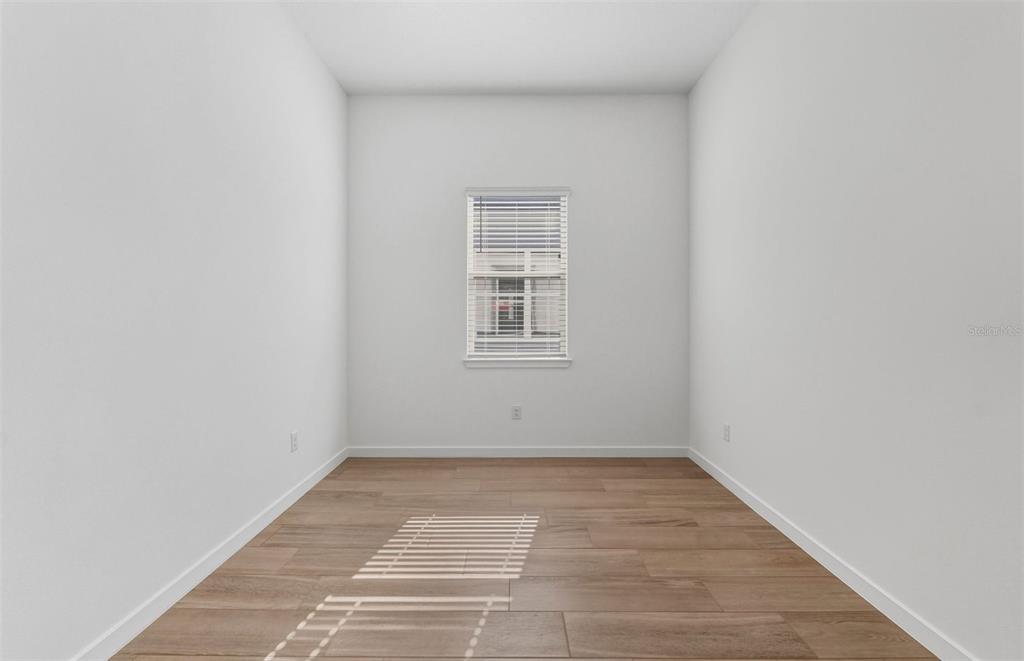 13647 Cyn Rdg Road Spring Hill, FL 34610 - Photo 15 of 30 a view of an empty room with wooden floor and a window
