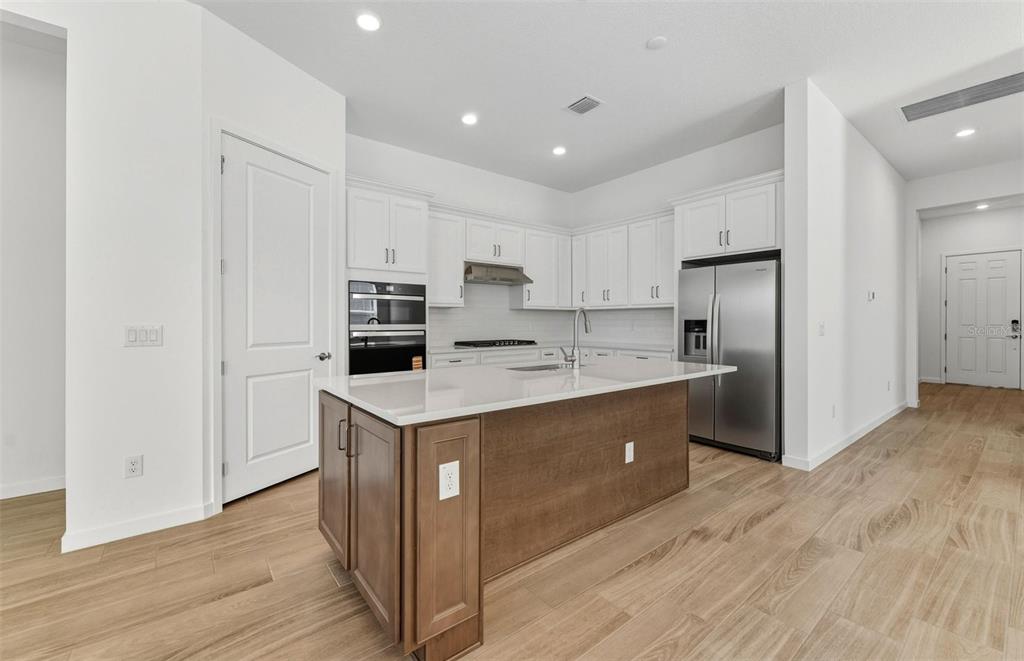 13647 Cyn Rdg Road Spring Hill, FL 34610 - Photo 2 of 29 a kitchen with white cabinets and stainless steel appliances