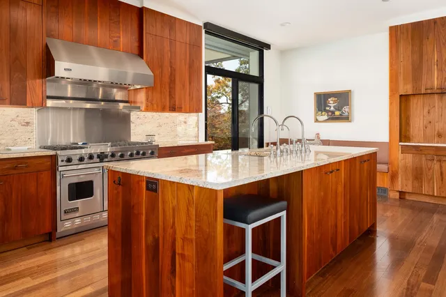 a kitchen with stainless steel appliances a sink cabinets and wooden floor