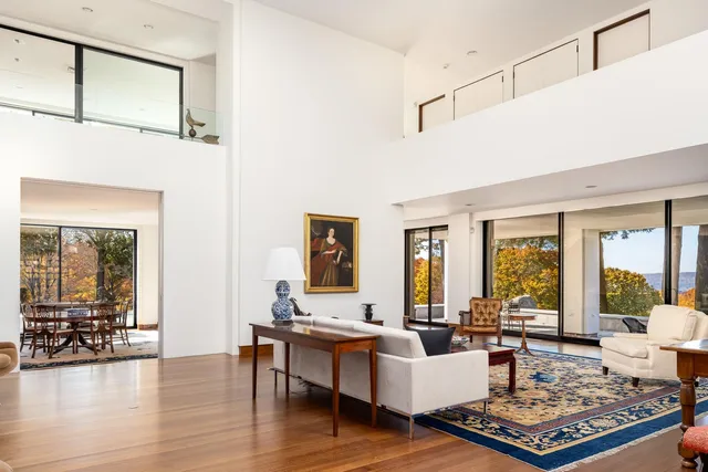 a living room with furniture large window and wooden floor