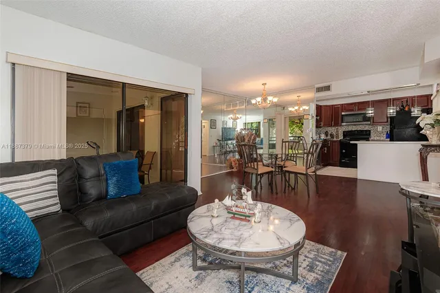 a living room with furniture and a dining table with kitchen view