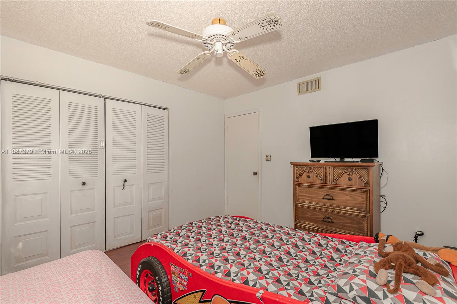 20015 Northeast 3rd Court, Unit 6 Miami, FL 33179 - Photo 16 of 31 a bedroom with a bed and a flat tv screen on the dresser
