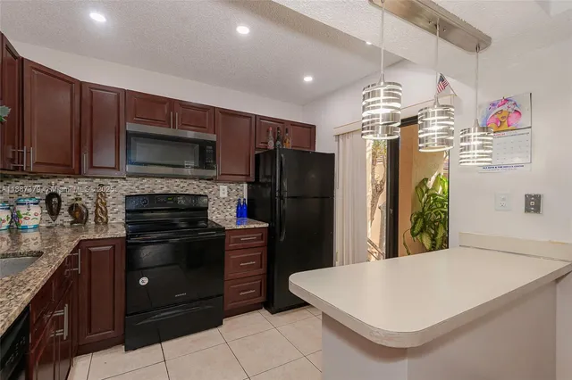 a kitchen with stainless steel appliances a refrigerator and a stove top oven