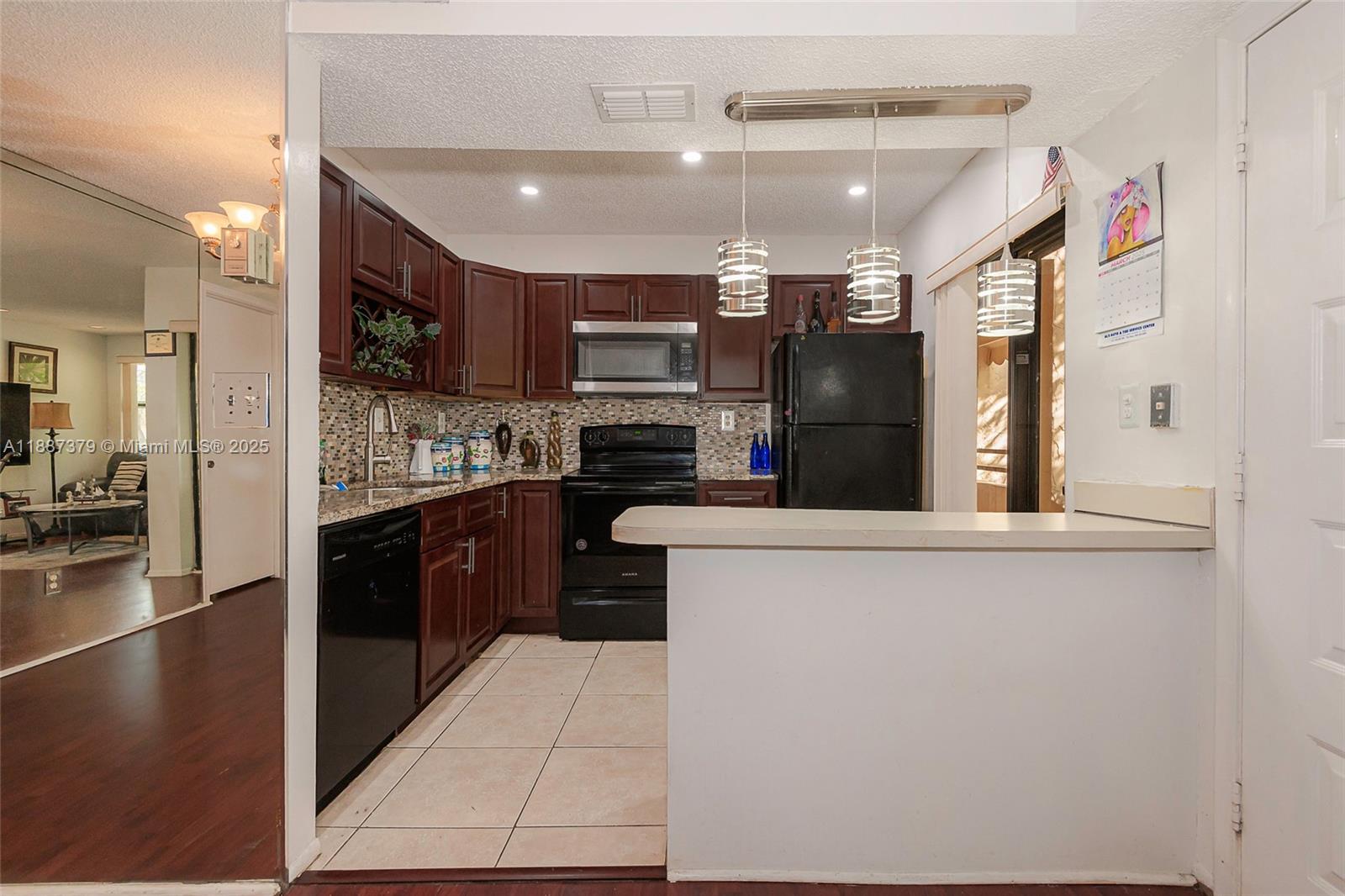 20015 Northeast 3rd Court, Unit 6 Miami, FL 33179 - Photo 8 of 31 a kitchen with stainless steel appliances kitchen island granite countertop a refrigerator and a sink