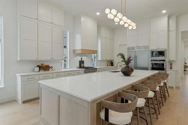 a kitchen with stainless steel appliances granite countertop a sink a stove and a refrigerator