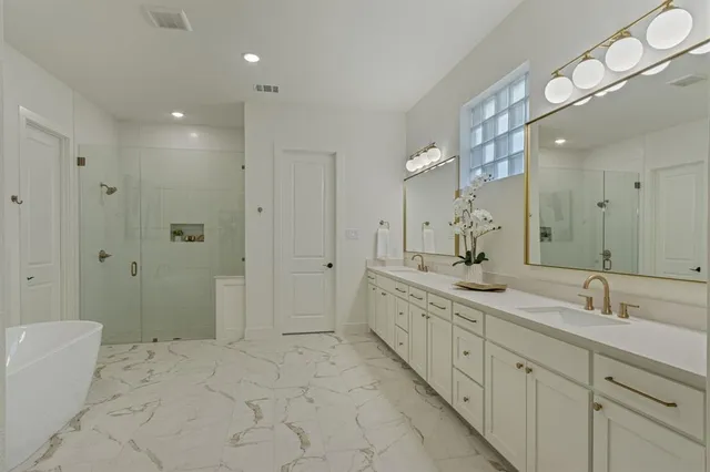 a spacious bathroom with a granite countertop sink a mirror a shower and a bathtub