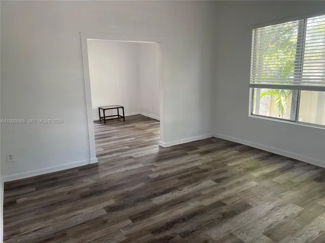 a view of a hallway with wooden floor and lounge chair