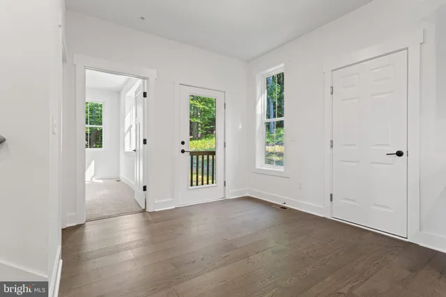 an empty room with a window and wooden floor