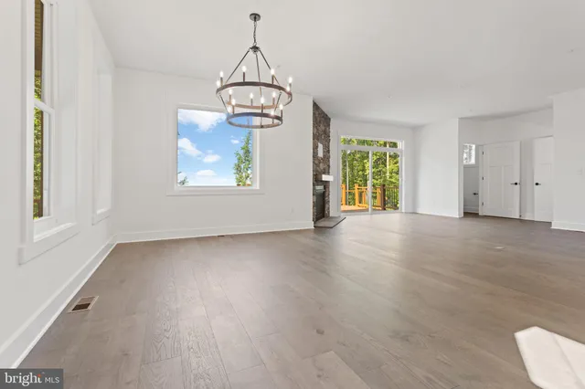 a view of empty room with wooden floor and window