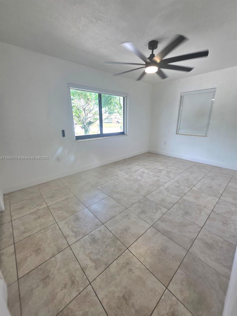 14900 Northwest 9th Court Miami, FL 33168 - Photo 4 of 8 an empty room with windows and fan
