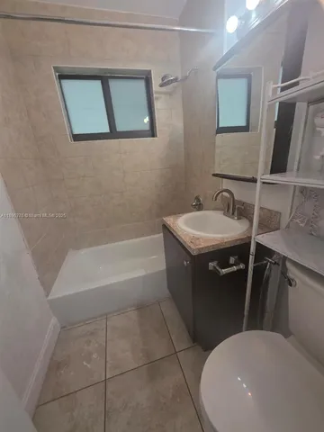 a bathroom with a bathtub sink vanity mirror and toilet
