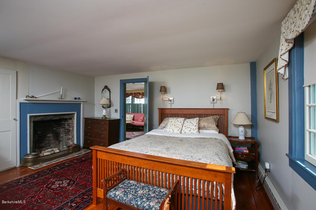 82 Chestnut Hill Loop Montague, MA 01351 - Photo 19 of 36 a bedroom with a bed and a fireplace