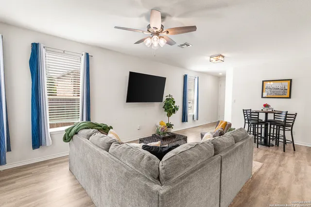 a living room with furniture a flat screen tv and a large window