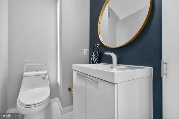a bathroom with a sink and mirror with toilet