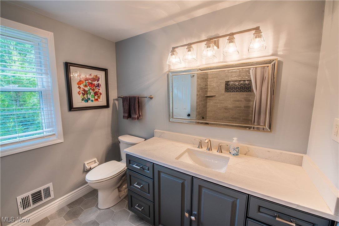 28314 Knickerbocker Road Bay Village, OH 44140 - Photo 32 of 38 Bathroom featuring tiled shower, vanity, toilet, and tile patterned flooring