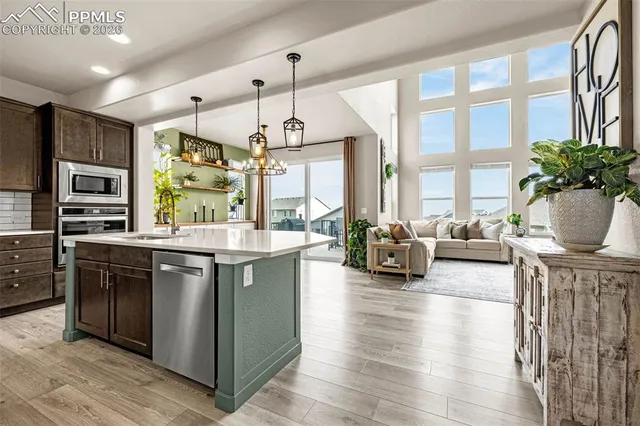 a kitchen with stainless steel appliances granite countertop a stove and a large window