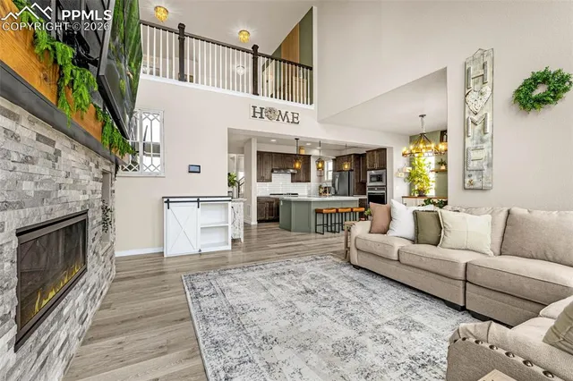 a living room with furniture a fireplace and a kitchen view