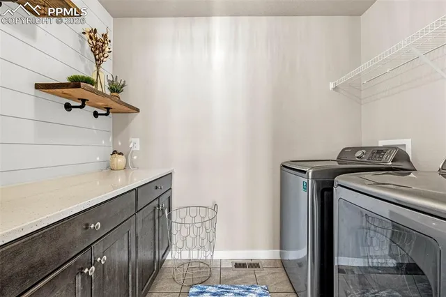a utility room with cabinets washer and dryer