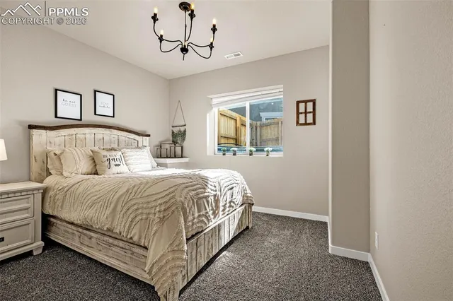 a bedroom with a large bed and a chandelier