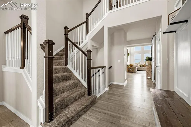 a view of a hallway with wooden floor and staircase