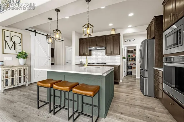 a large kitchen with a table and chairs
