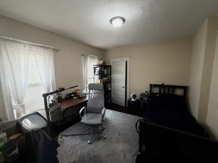 a view of a workspace with furniture and a window