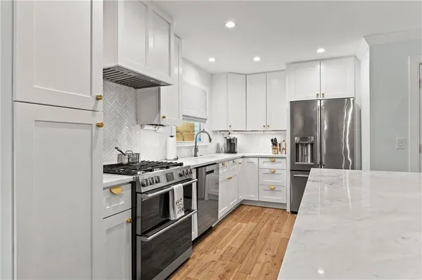 a kitchen with stainless steel appliances a stove a sink and a refrigerator