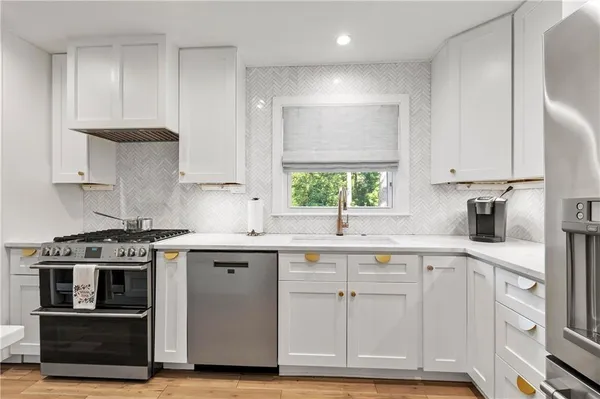a kitchen with stainless steel appliances granite countertop a stove a sink and a refrigerator
