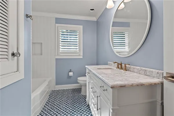 a bathroom with a granite countertop sink a toilet and a mirror