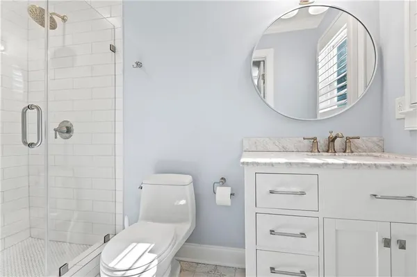 a bathroom with a granite countertop sink toilet a mirror and shower